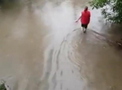 Двор-море сняли в Кировском районе на видео: женщина еле удержалась на ногах