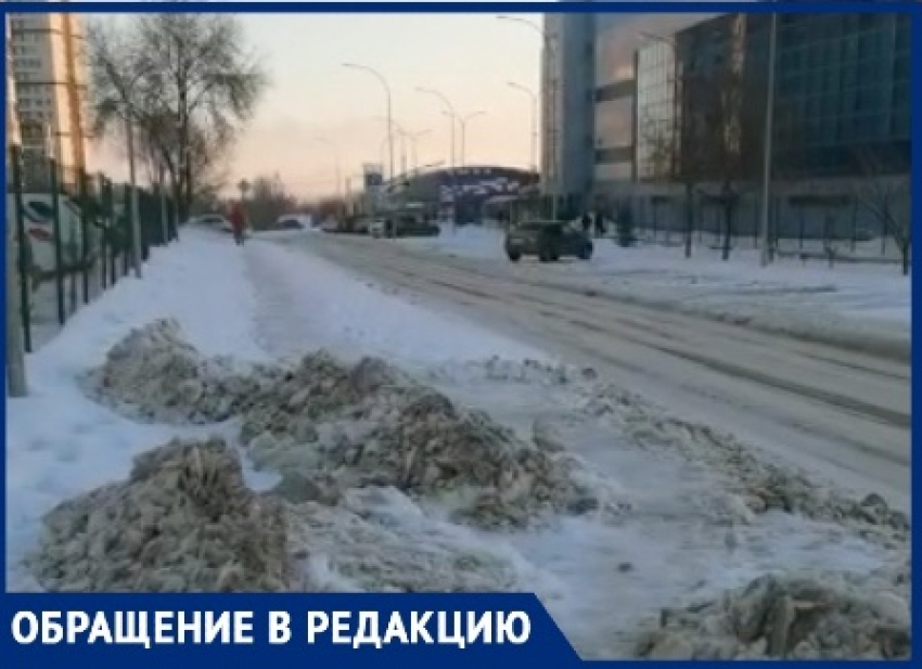 Возле спорткомплекса снег вывезли с проезжей части на тротуар в Волгограде: видео 