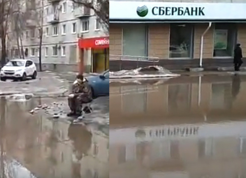 Рыбалка с удочкой в огромной луже перед Сбербанком попала на видео в Волгограде